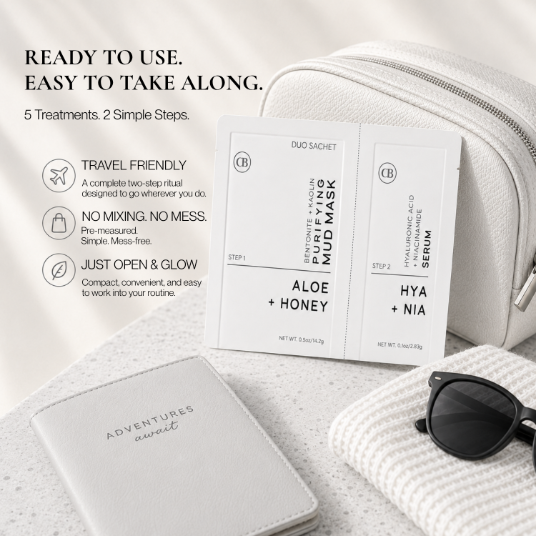 A travel skincare set laid out on a light neutral surface, including a white pouch, a white card holder with embossed branding, a dual-sachet mask packet labeled Purifying Mud Mask,