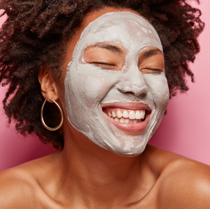 Woman with a gray face mask on a pink background