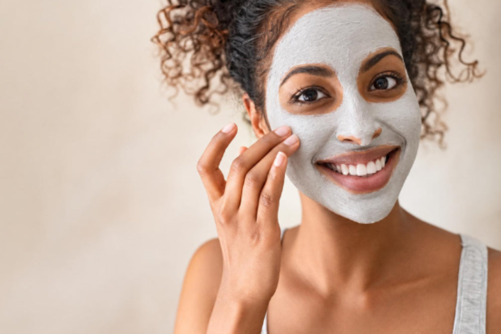 Women with curly hair applying Clay mask