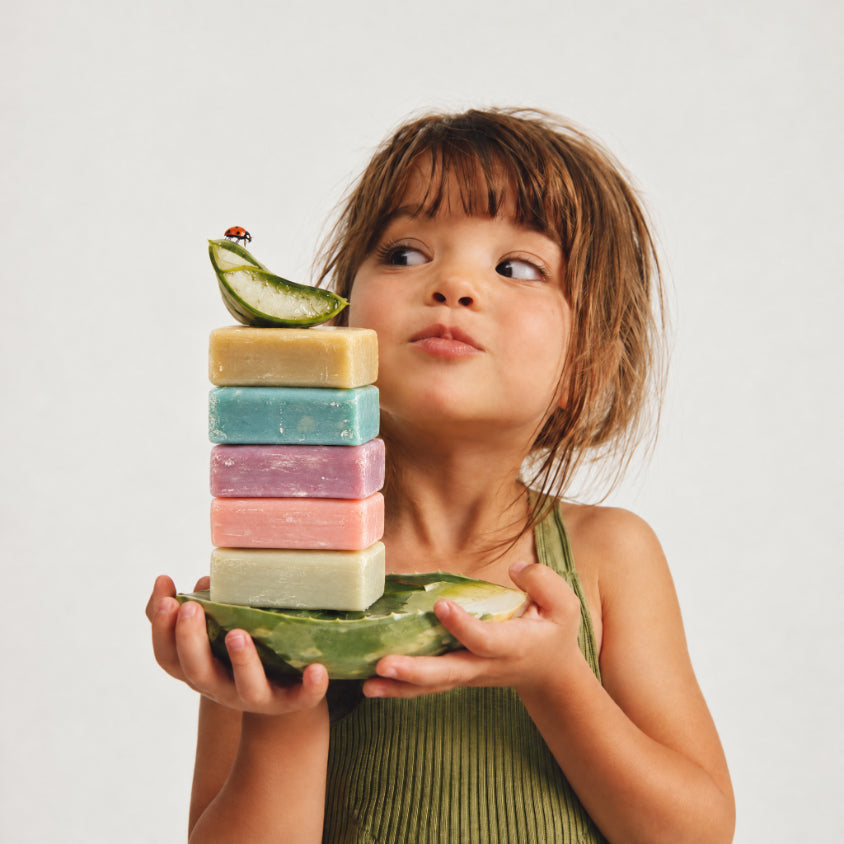 Young girl holding stack of mineral soap